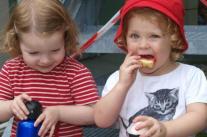 Zwei Kinder essen Apfel