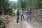Drei Personen diskutieren auf einem Forstweg.