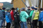 Frau steht mit Kindern vor Silo