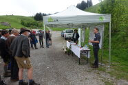 Personen stehen vor Pavillon im Freien