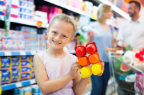 Kind hält sechsteilige Joghurtverpackung in Supermarkt 
